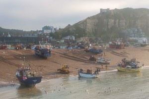 Fishing boats being dragged ashore in Hastings, East Sussex England. The ancient seafaring town of Hastings has the largest remaining shore-based fishing fleet left in Britain