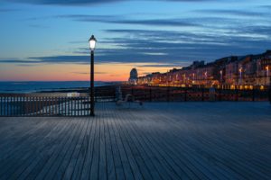 English Seaside: Lights glow in the twilight along the seafront at the old seaside holiday town of Hastings on the Sussex coast