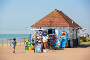 English seaside: Kiosk at Bexhill overflowing with bright plastic toys for a bucket-and-spade holiday by the seaside
