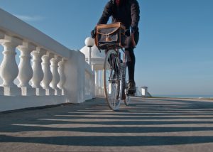 Cycling along the seafront at Bexhill, through light and shadow from the King George V Colonnade in Bexhill-on-Sea