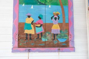 Painted shutters with bright Caribbean scene of three ladies on shop Road Town Tortola BVI British Virgin Islands