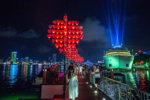 The waterfront along the Han river comes alive with lights and music and laughter on a warm summer night; Da Nang, Vietnam
