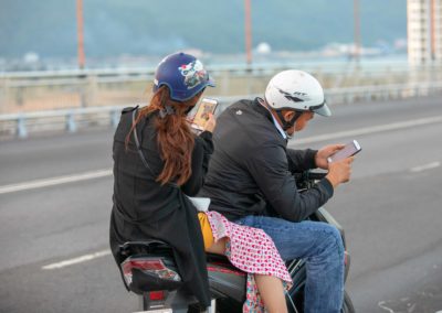 An urge to text drew this couple to the side of the road doing the evening rush hour in Da Nang, Vietnam,